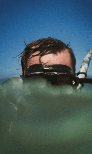 person wearing snorkle gear in water