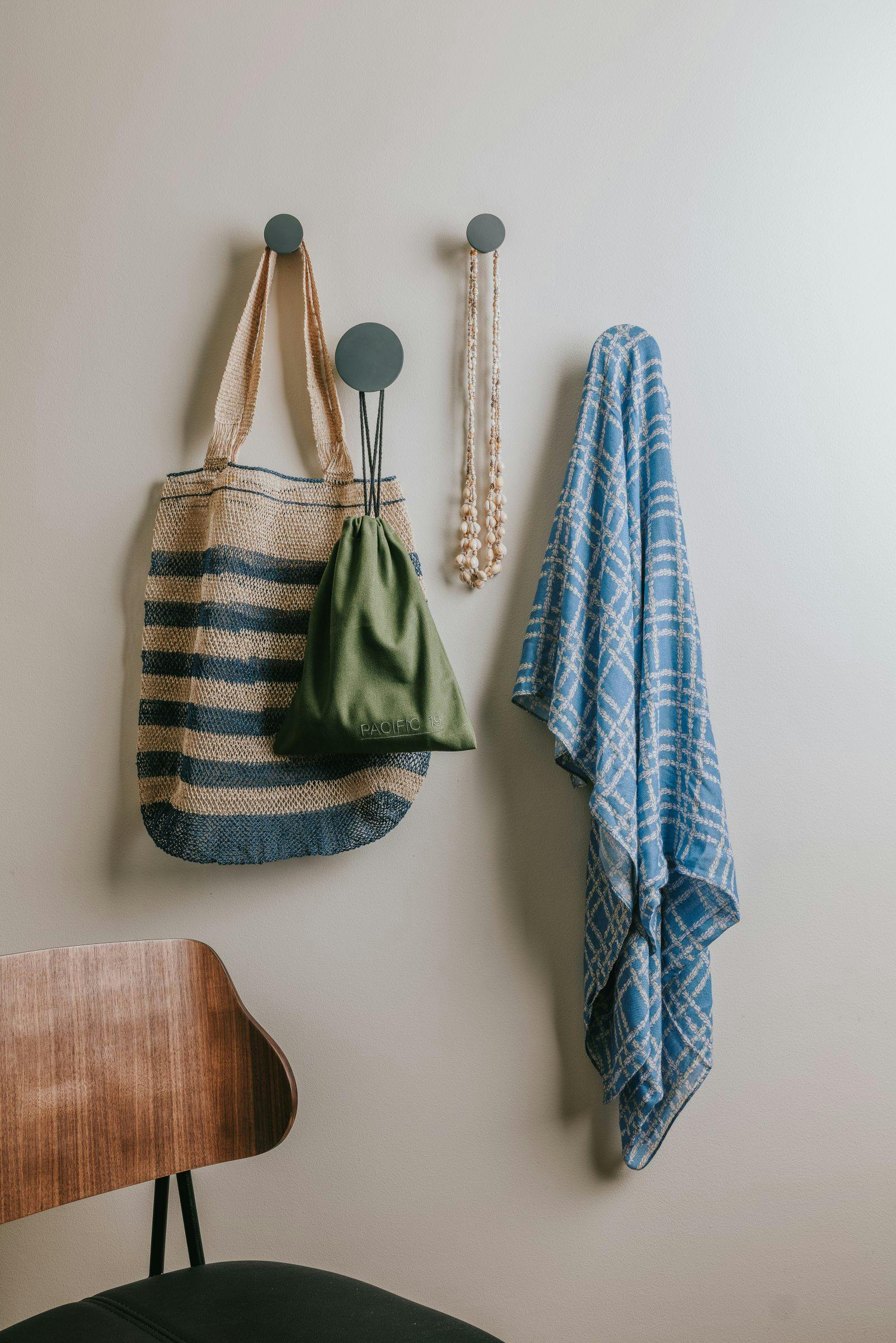 bag necklace and towel hanging on a hooks on the wall