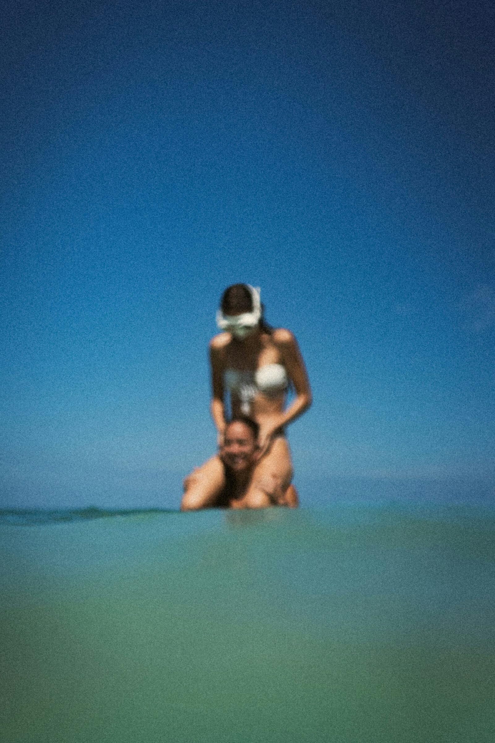 person carrying a person on shoulders in the water